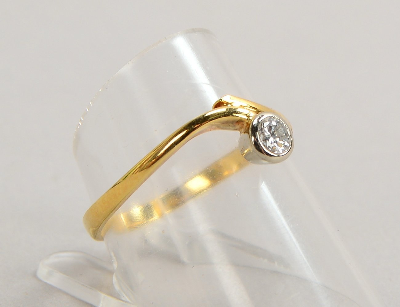 Ring, 585 GG (gest.), mit einzelnem kl. Brillant von ca. 0,18 ct; RG 57, Gew. 2,20 g
