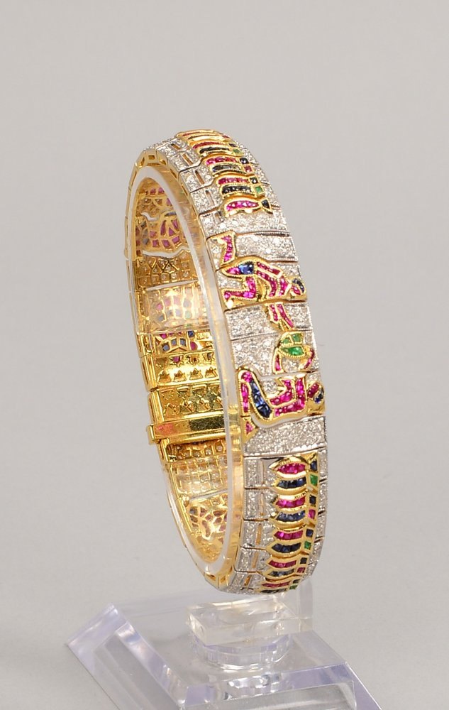 Exkl. Armband, 585 GG/WG (gest.), ägypt. Motiv, div. Steinbes./Diam.; Gew. 37 g