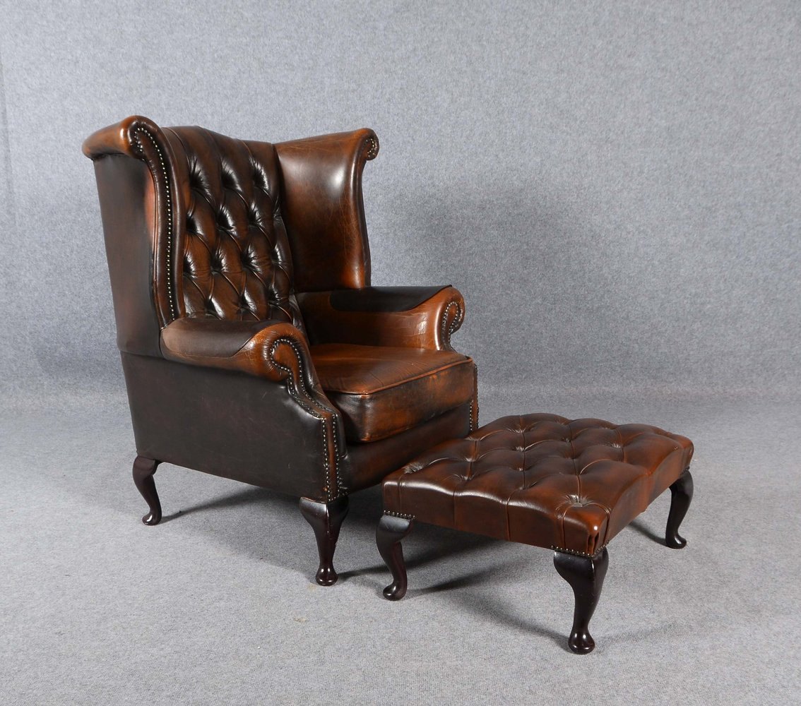Chesterfield-Sessel, dunkelbraunes Leder, mit Sitzkissen, mit passendem Fußhocker