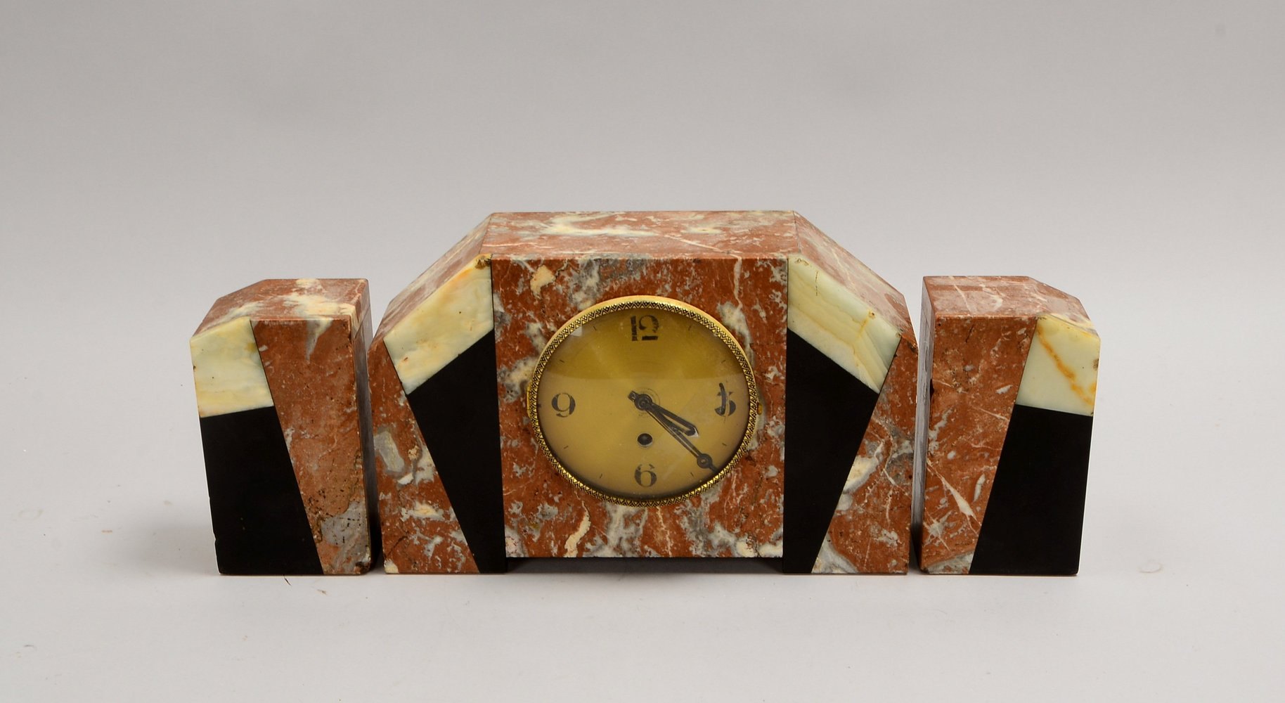 Tischuhr (Art déco), Gehäuse mehrfarbiger Marmor, Uhr läuft an; mit 2x Beistellern