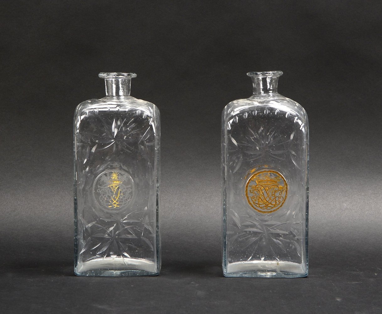 2 antike Flaschen, wulst. Mündung, geschl. farbl. Glas, mit 'Wappen'/Blattornam.