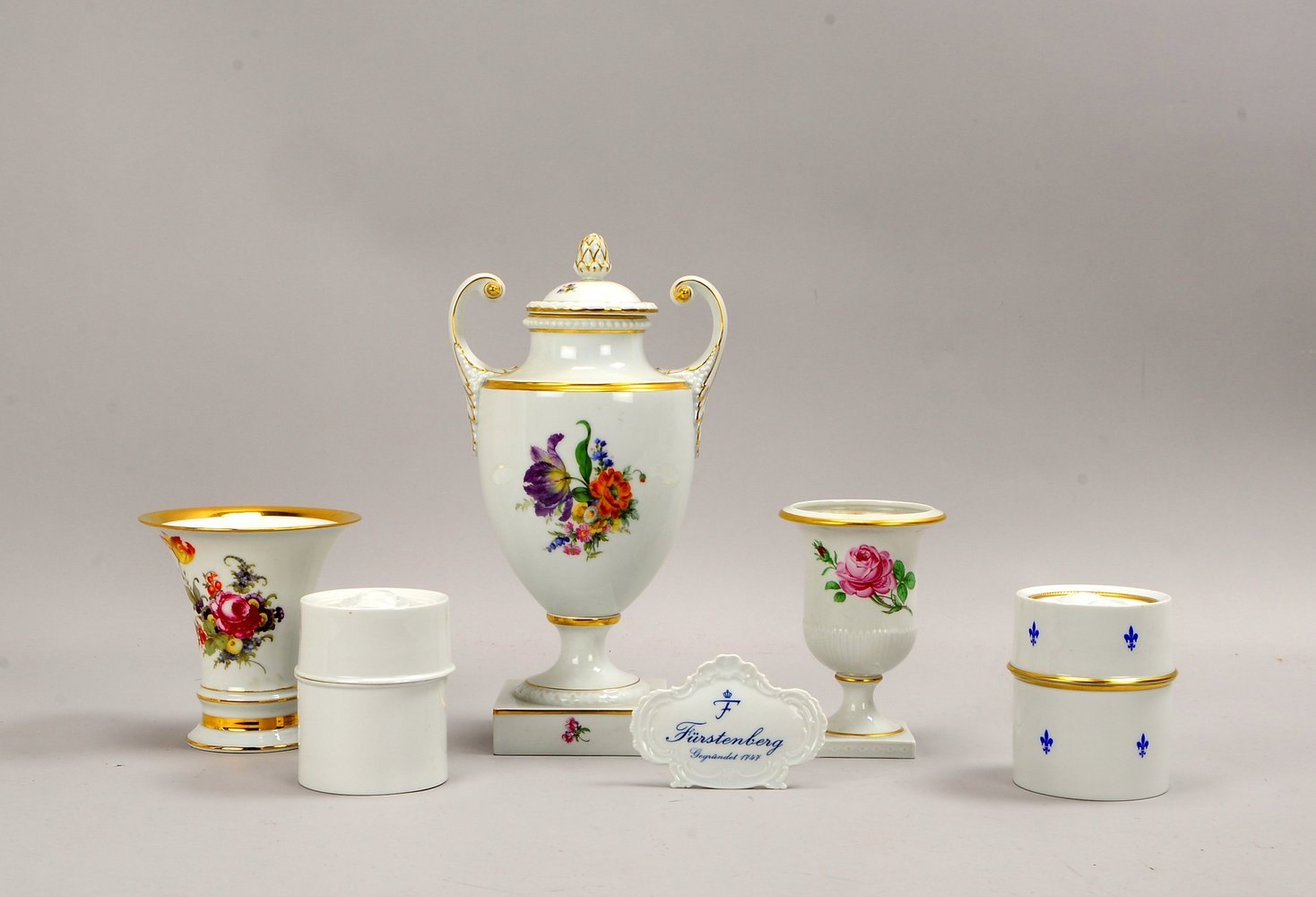 Fürstenberg, 8 Tischporz.-Teile, polychr./goldstaff.; Aufsteller und Deckelvase, Höhe 32 cm