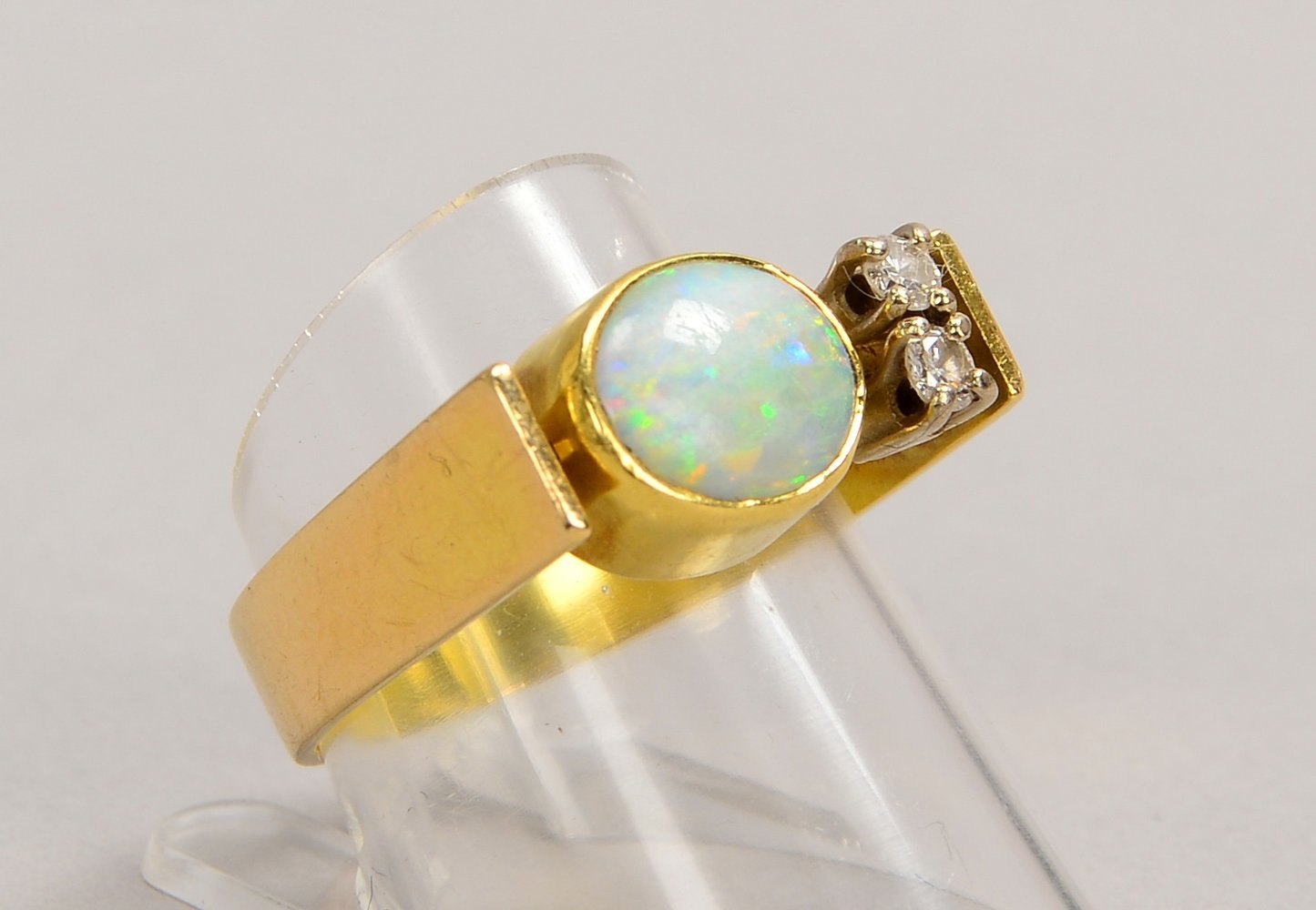 Ring, 585 GG (gest.), mit einzelnem Opal-Cabochon und 2x kl. Brill.; Gew. 6,10 g