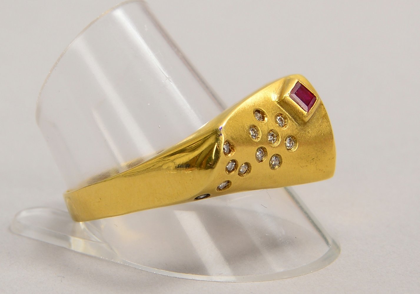 Ring, 585 GG (gest.), matt., mit 12x kl. Brill./ca. 0,12 ct, und Rubin; RG 67, Gew. 6,63 g
