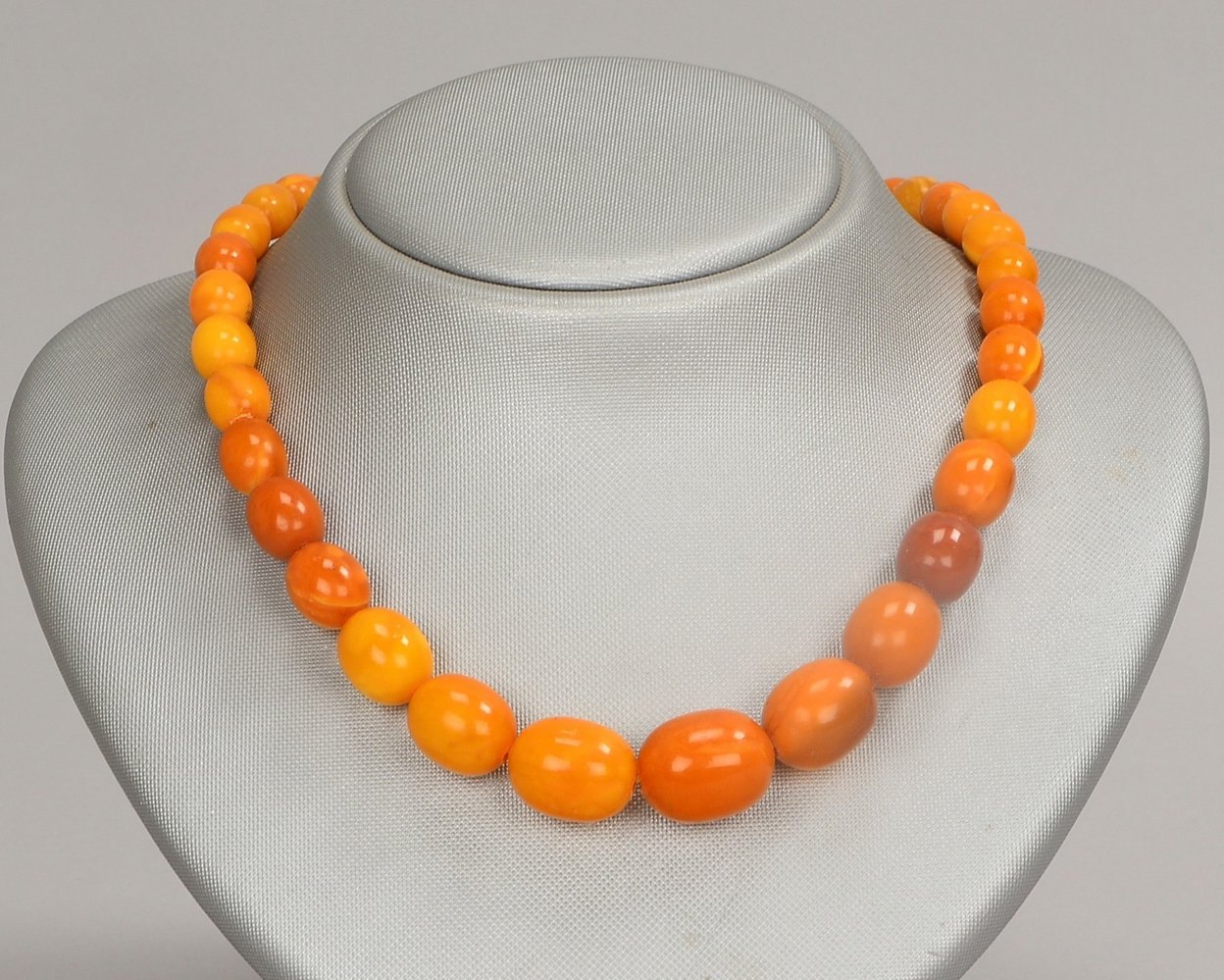Bernsteinkette, opaque Steine, olivenf./verl., mit Karabinerschl.; Länge 54 cm, Gew. 33 g