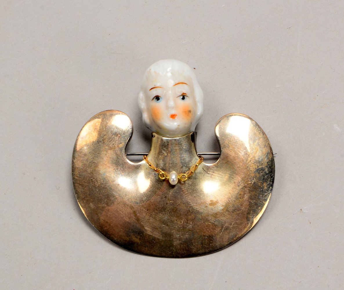 Brosche, 925 Sterlingsilber, mit polychr. Porz.-Einsatz ('Kopf') und kl. Holzkette/mit Perle