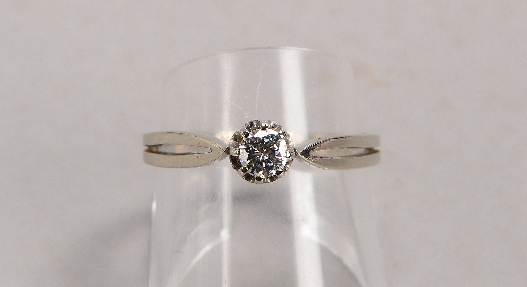 Ring, 585 WG (gestempelt), besetzt mit einzelnem Brillant von ca. 0,20 ct, getöntes Weiß - Weiß, Vsi