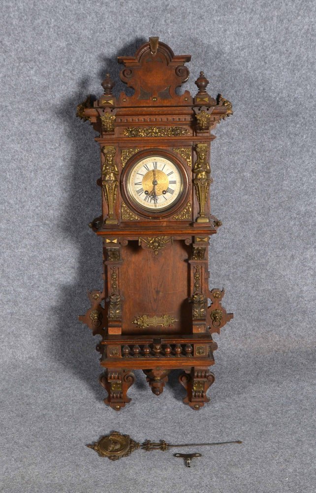 Wanduhr (Gründerzeit), Nussbaum, geschn./mit figürl. Messing-Applikationen