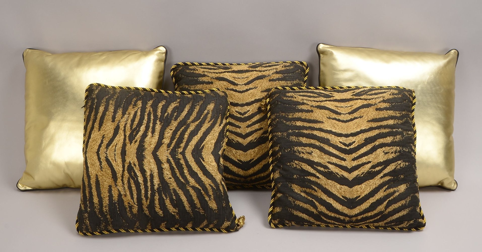 5 Kissen (wohl Atel. Versace): 2x goldf. Kunstleder/schw. Leder, 3x in Tiger-Optik