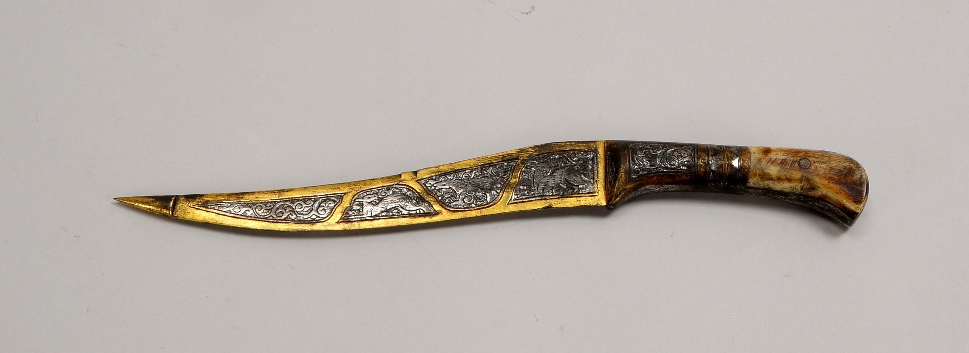 Kl. Dolch (wohl Qajar/Iran), Klinge mit ornament./figürl. Ziselierung, Griff mit Horn(?)