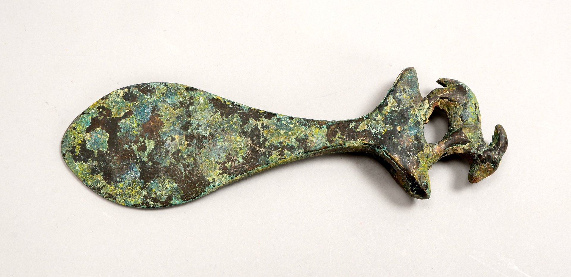 Bronze-Beil (Fundort/Alter unbek.), mit figürl. Bekrönung ('Zicklein'), grüne Patina