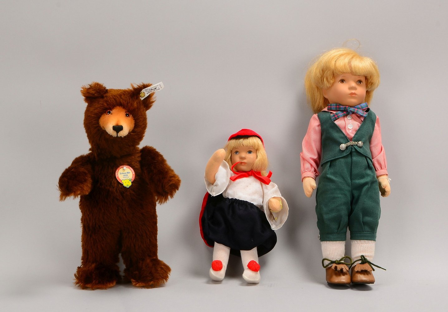 2 Käthe Kruse-Puppen, Kunststoff-Kopf/Stoffkörper, und Steiff-Teddy 'Zirkus-Bär'
