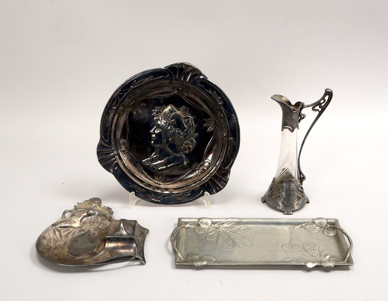 Kleines Zinnteile-Konvolut (Jugendstil), 4 Stück: 1 Karaffe, 1 Tablett und 1 Wandteller, sowie 1 Tin
