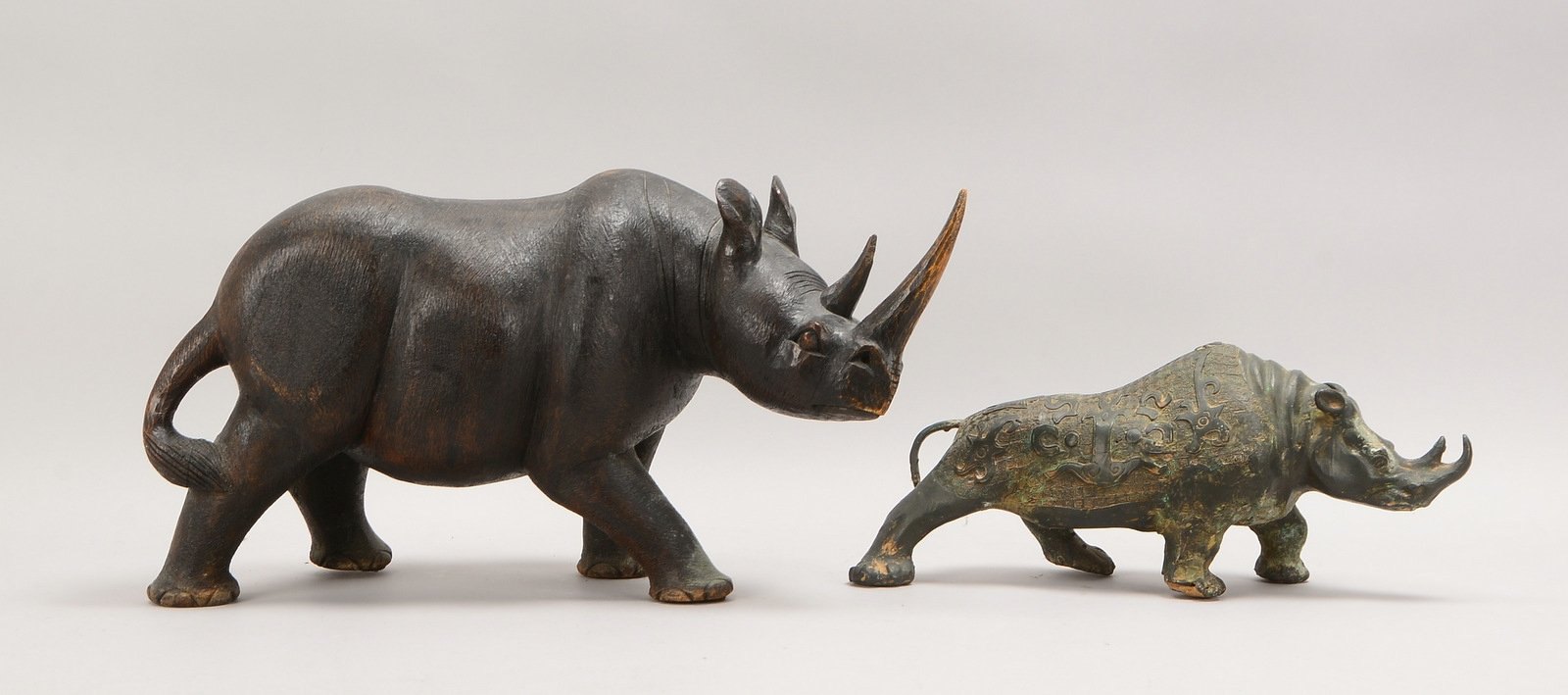 2 Tierskulpturen: 'Nashorn', Holz, Länge 56 cm; und 'Rhinozeros', Weißmetall, Länge 41 cm