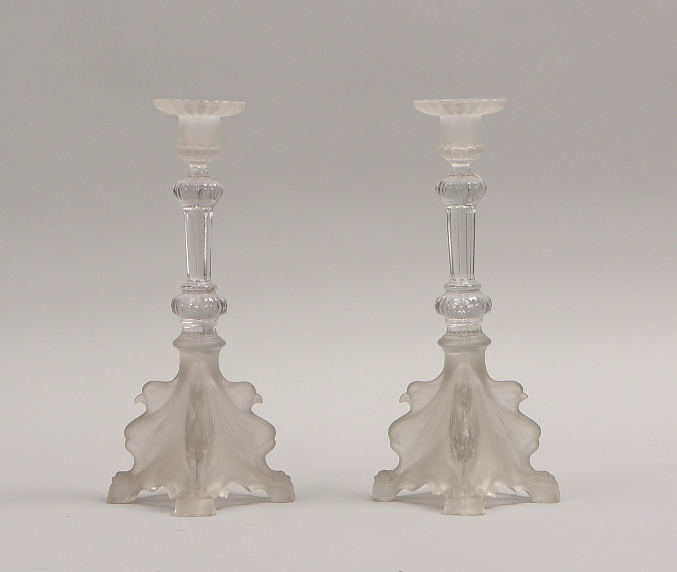 2 Kerzenleuchter, Glas teils matt., 4-pass. Fuß mit figürl. Vogelmotiven; Höhe 27,5 cm