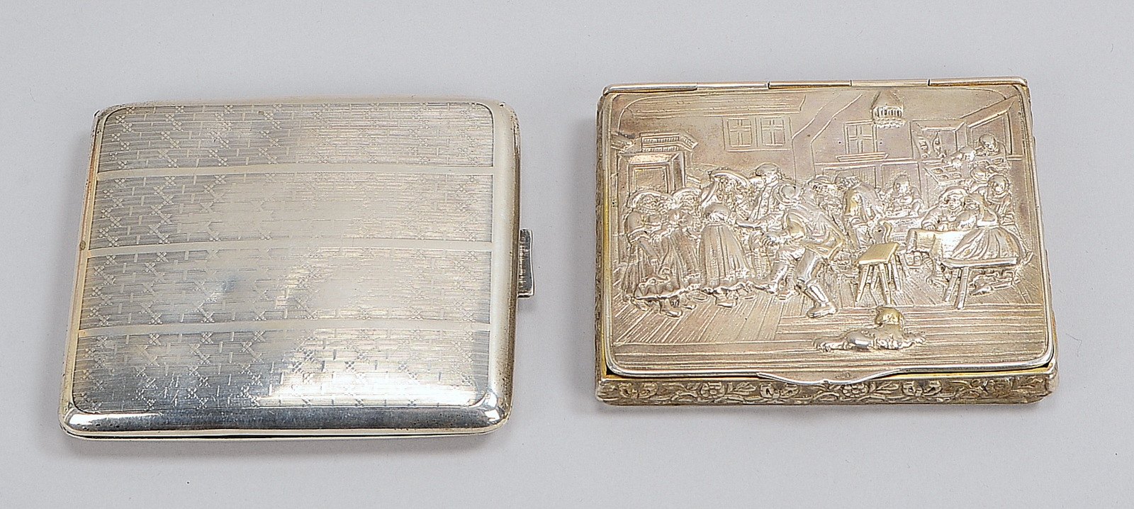 2 Zig.-Etuis: 1x 800 Silber, relief. 'Wirtshausszene'; 1x 835 Silber, ornament.; Gew. 210 g