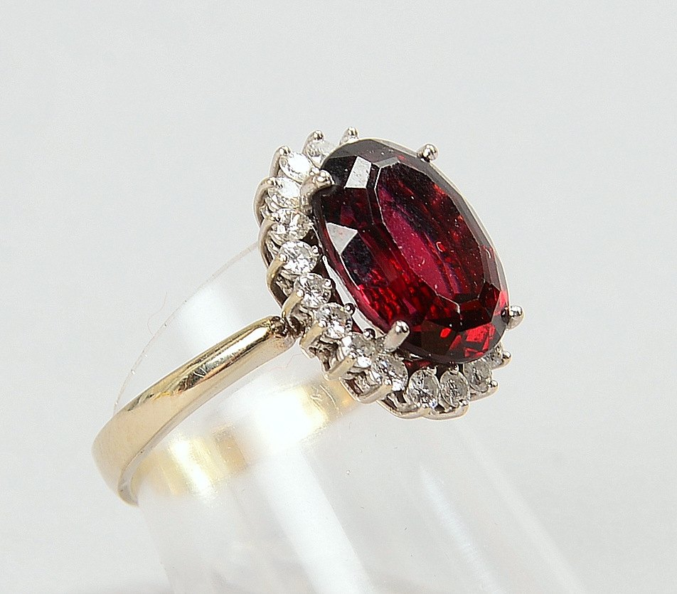 Ring, 750 WG (gest.), fac. Granat im Ovalschliff, mit Brill.-Entourage; RG 54, Gew. 6 g