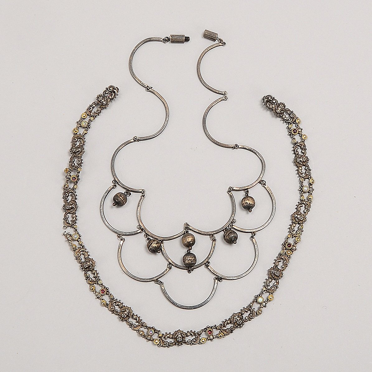 2 Halsketten, Silber: 1x barock, relief. mit Rubinen/Opalen; 1x 3-reihig, halbkreisf. Glieder
