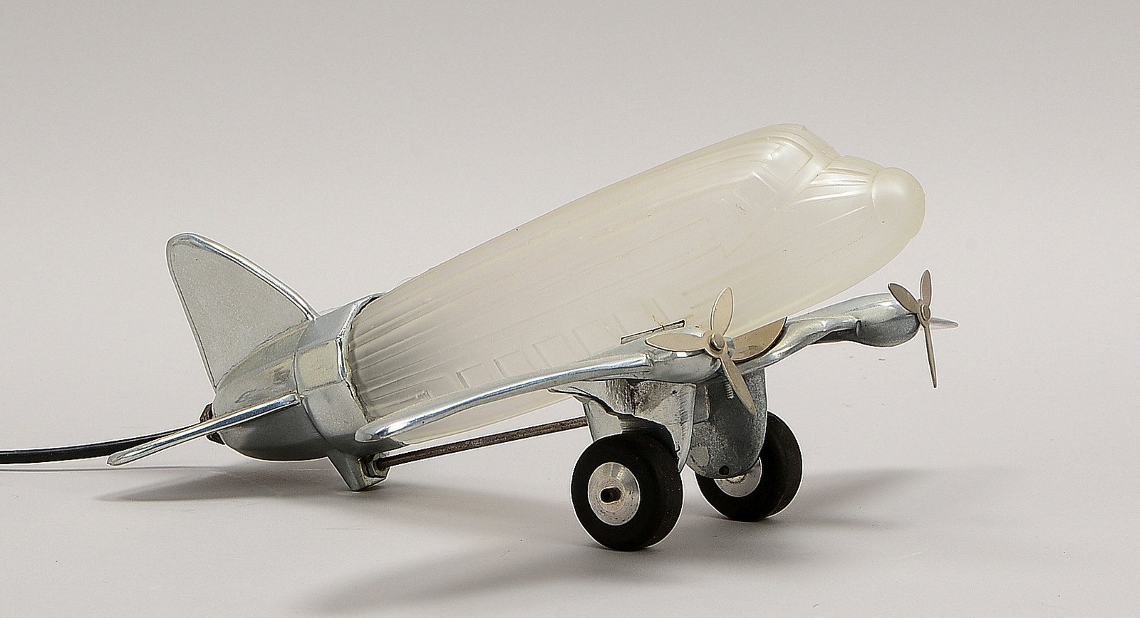 Sarsaparilla, figürl. Tischlampe, 1-fl., Flugzeugmod. 'Dacota DC3', Alu/Metall und farbl. Glas