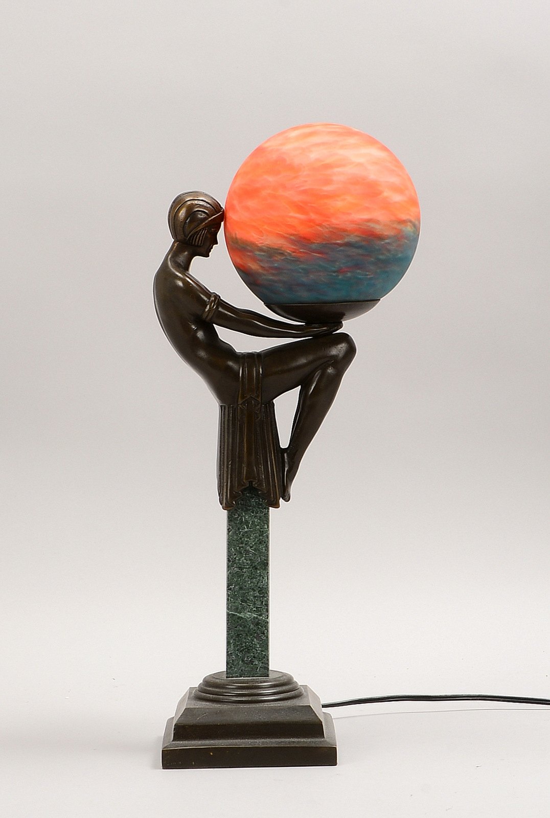 Tischlampe (Art déco), Bronze-Schaft, Figur auf Sockel, orangef. Glasschirm/farb. Einschm.