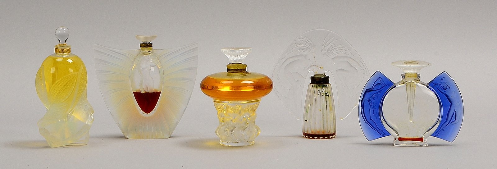 Lalique, 5 Parfumflacons, Glas, relief./figürl. ('Weibl. Akte'); Höhe 10 cm - 14,5 cm