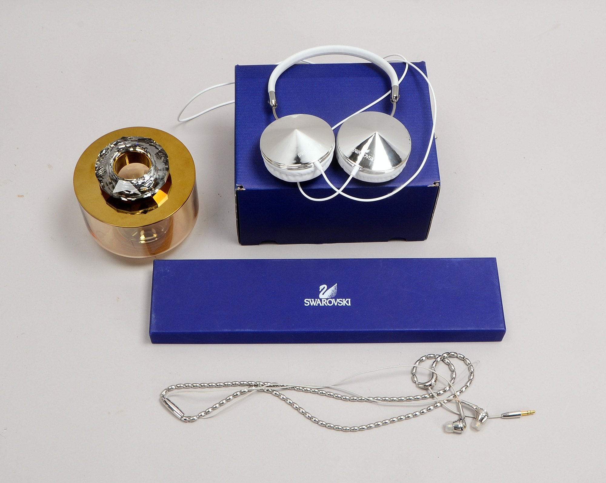 2 Swarovski-Kopfhörer: 'Over ear', mit Bügel; und 'In ear', mit Box/'Allure'-Box 'Crystal Gold'