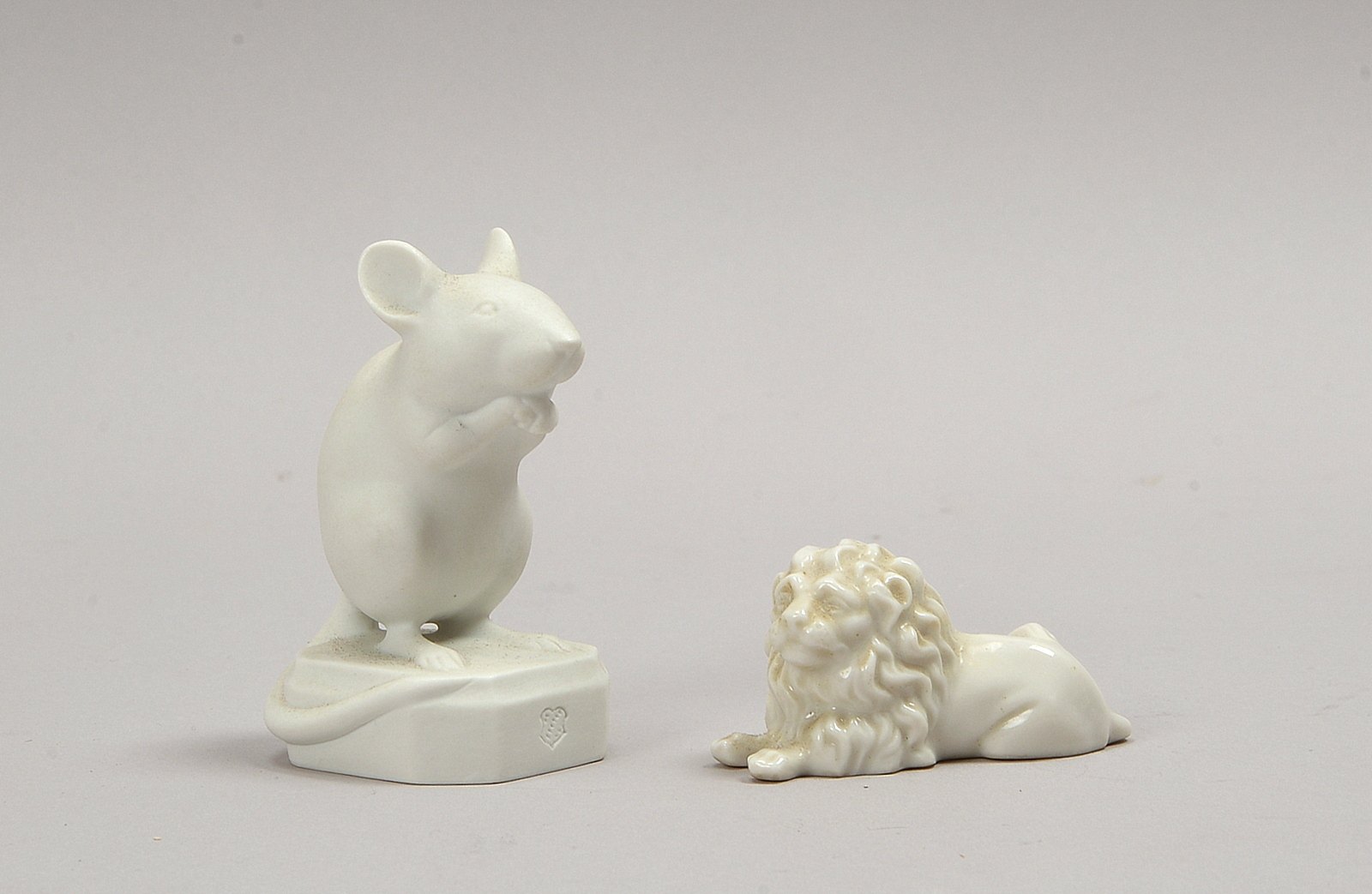 Nymphenburg, 'Springmaus', Höhe 3,5 cm; und 'Liegender Löwe', Höhe 7,5 cm