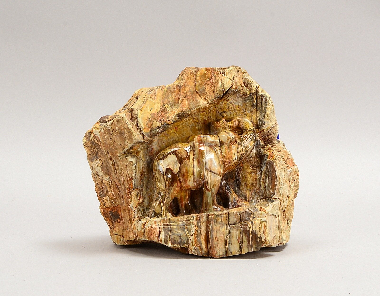 Steinskulptur, 'Elefant', halbplastisch, wohl versteinertes Holz/geschnitzt und poliert