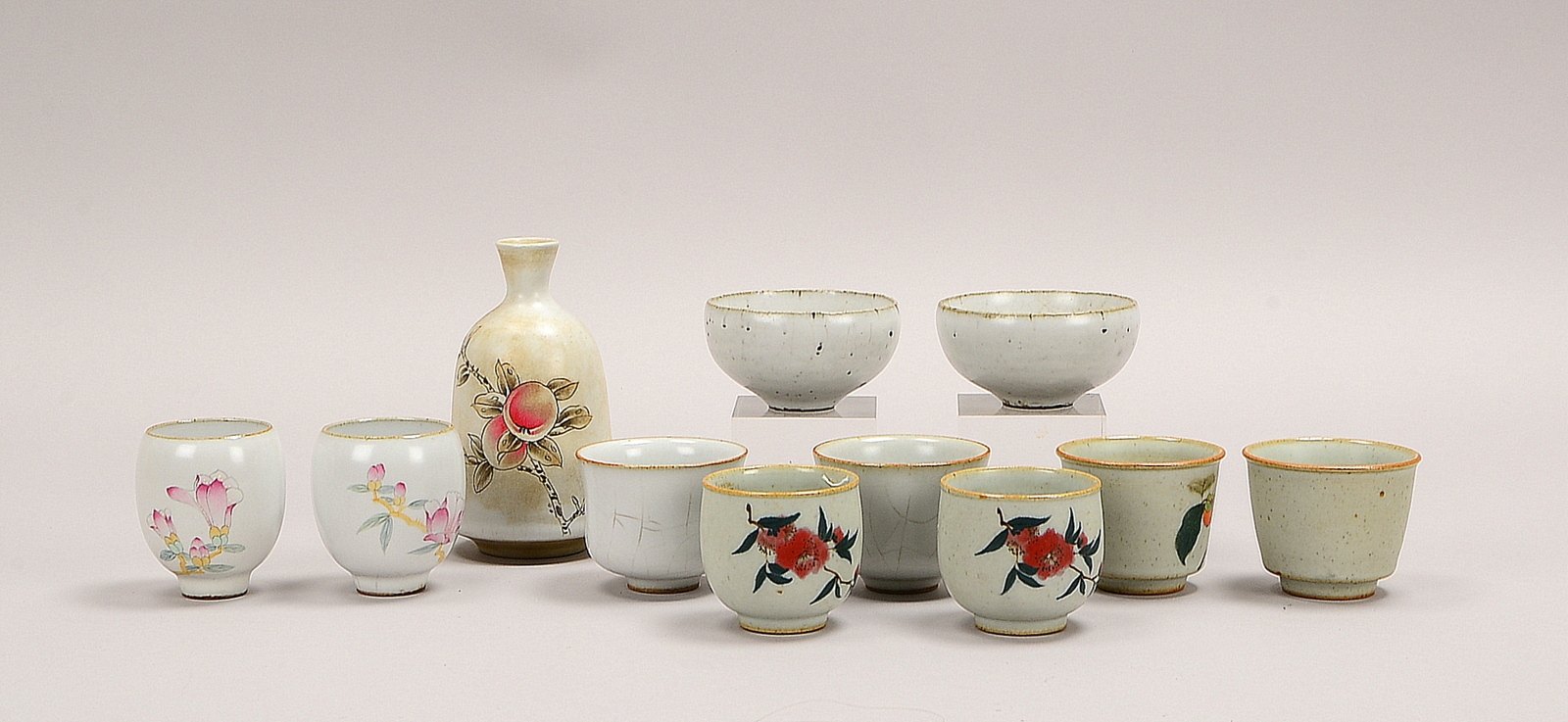 Tassen-Konvolut (China), Steinzeug glasiert, teils florales Dekor, 5 Paare, 1 Flasche