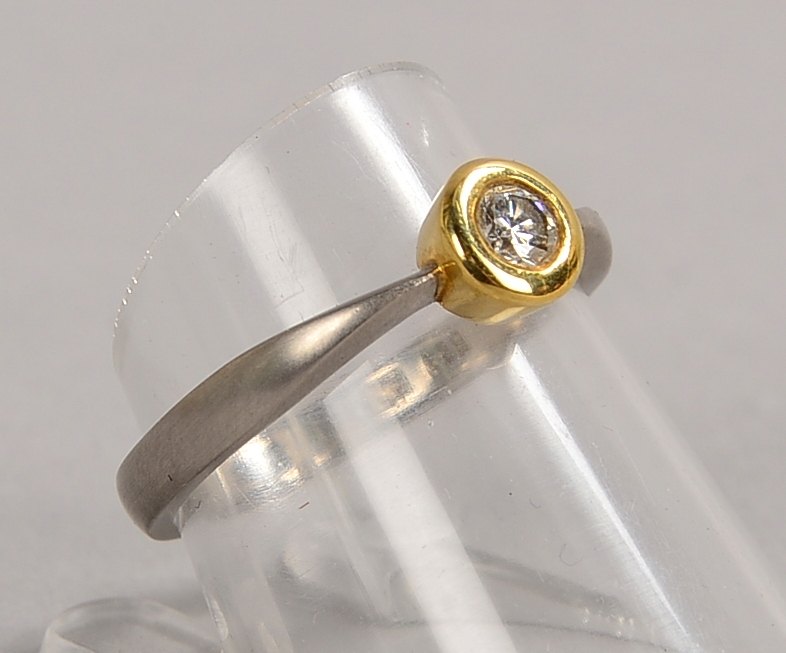 Ring, 585 GG/WG (gest.), mit einzelnem kl. Brillant von ca. 0,17 ct; RG 55, Gew. 3,60 g