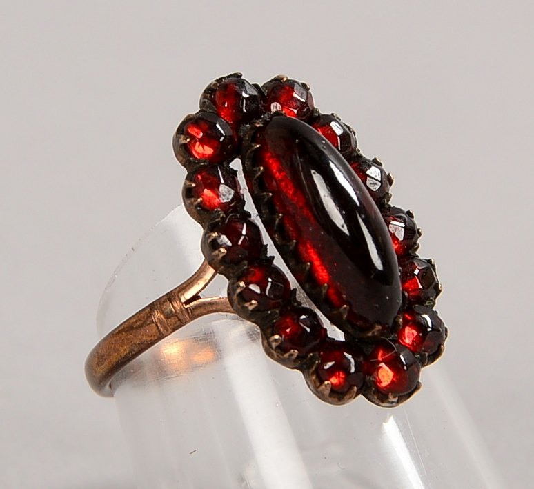 Ring, 585 RG (gest.), mit Granatcabochon und einer Entourage aus kl. Steinen; Gew. 4,40 g
