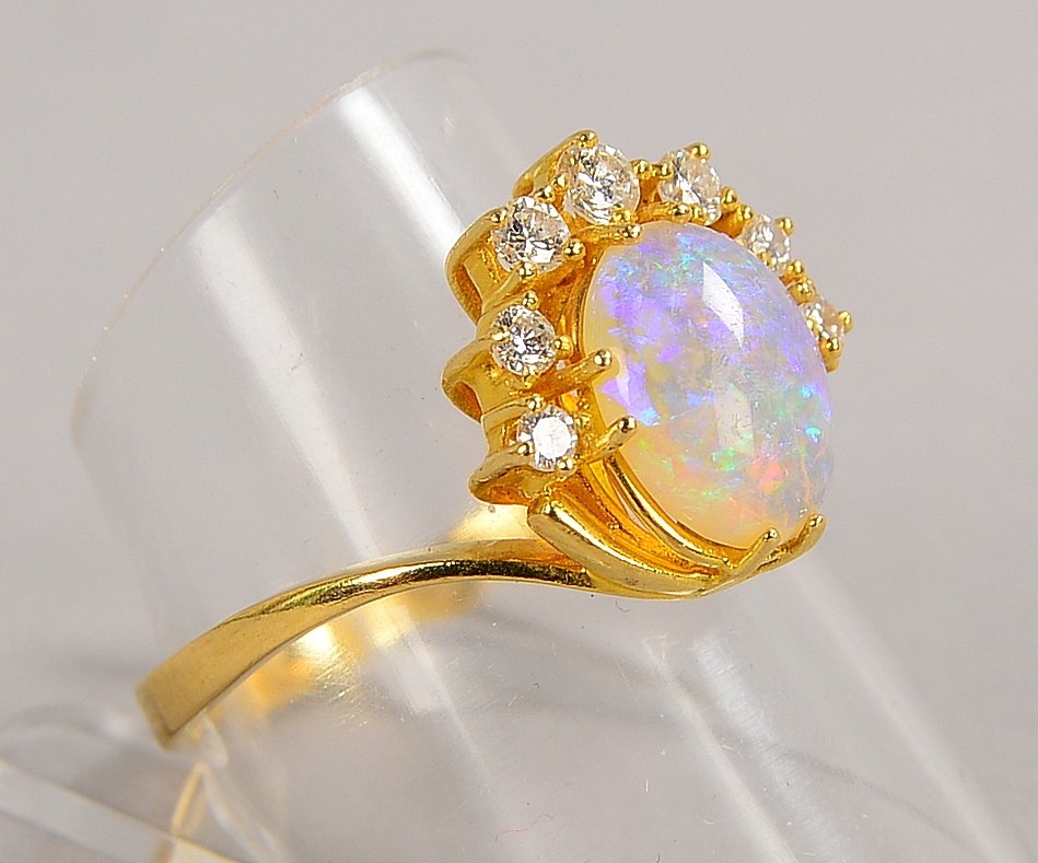 Ring, 750 GG (gest.), mit einzelnem Opal und 7x kl. Brillanten/ca. 0,25 ct; Gew. 4 g