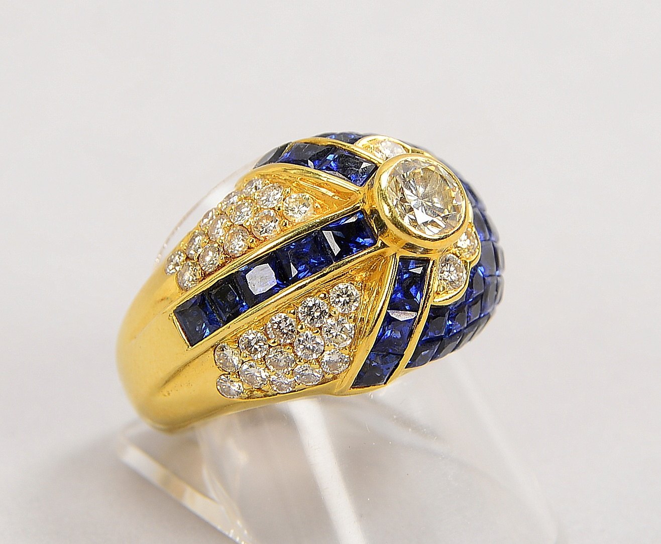 Ring, 750 GG (gepr.), mit Brillant von ca. 0,65 ct, kl. Brill./1,20 ct und Saphiren; Gew. 25,50 g