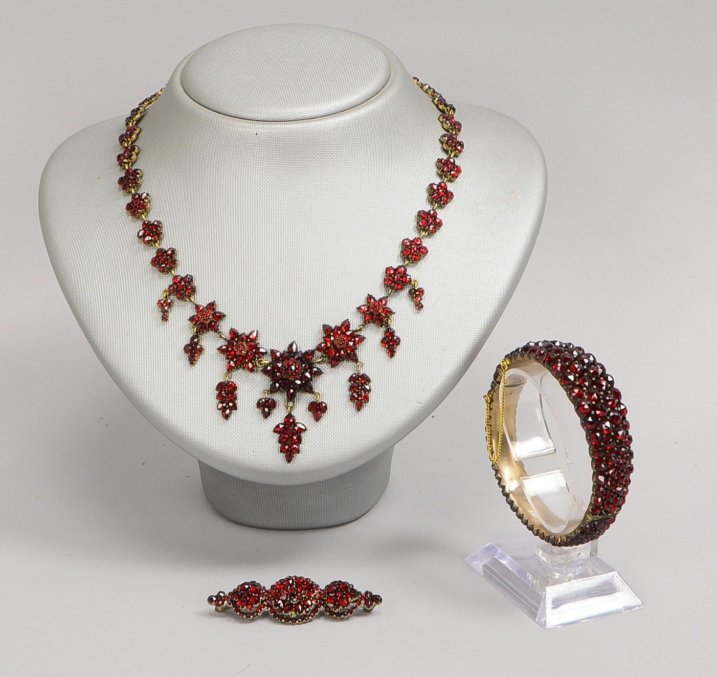 Schmuckset mit Granatbesatz: Collier, Länge 41 cm; Armreif, Ø 5 x 5,5 cm; und Brosche
