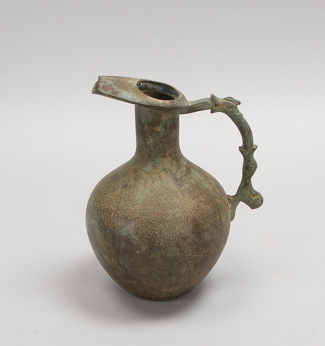 Henkelkrug (Persien - islamisch), Bronze, mit ornamentalem Dekor, figürl. Griff; Höhe 23 cm