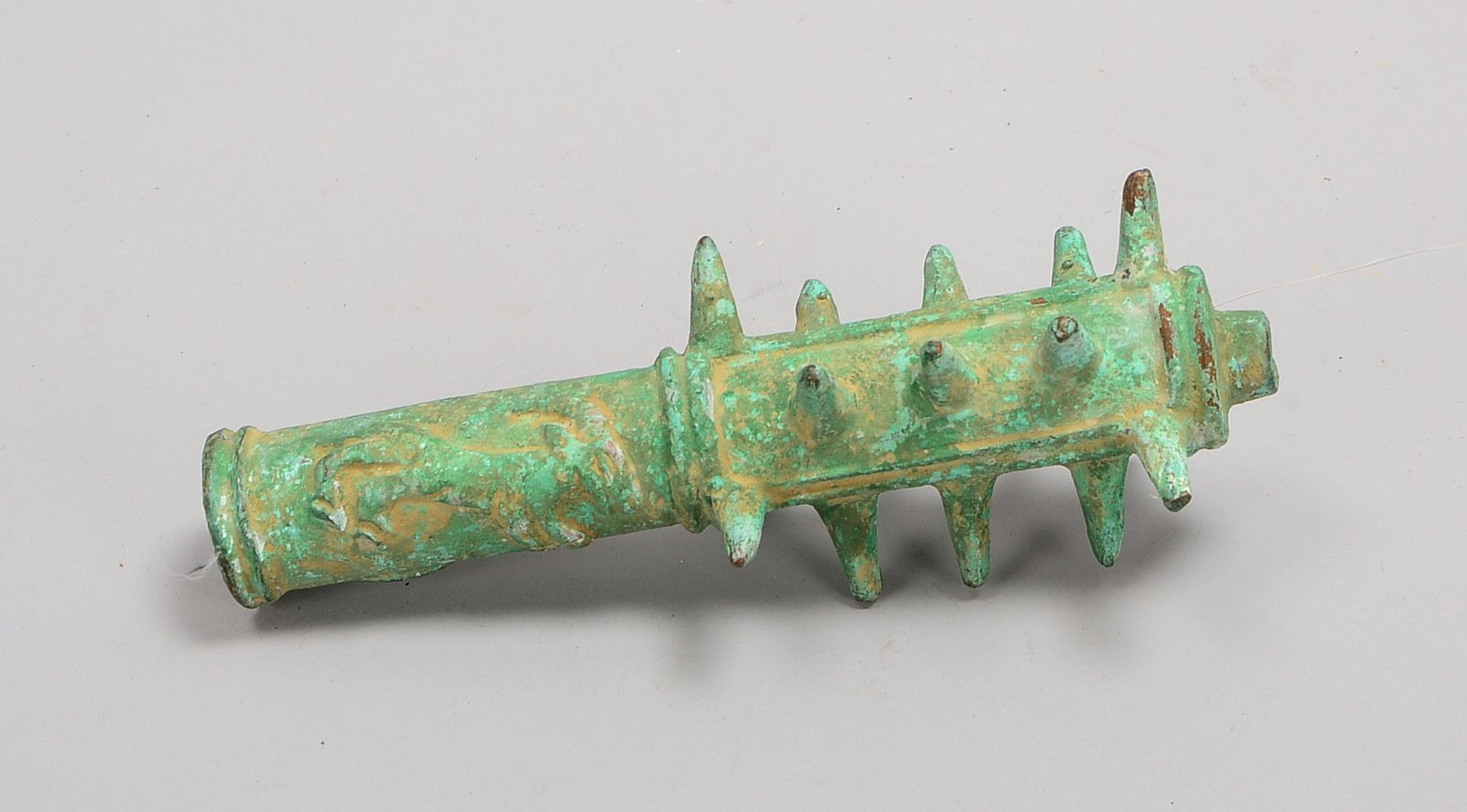 Bronze-Keule (Luristan/Persien), Bronze mit grüner Patina, figürl. Reliefdekor; Länge 21,5 cm
