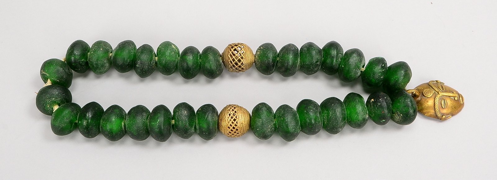 Collier, 30x grüne Glasperlen, rund/gedrückt, 2x Bronze-Kugeln und figürl. Anh.