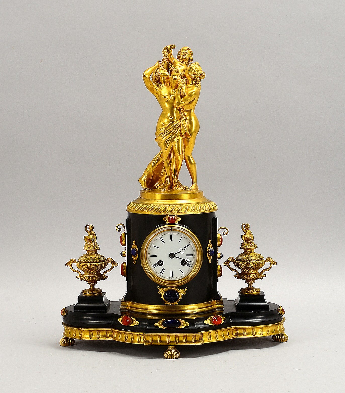 Prunk-Kaminuhr, Messingwerk/Schlag auf Gl., figürl. Bronze-Aufsatz, 2x Beisteller