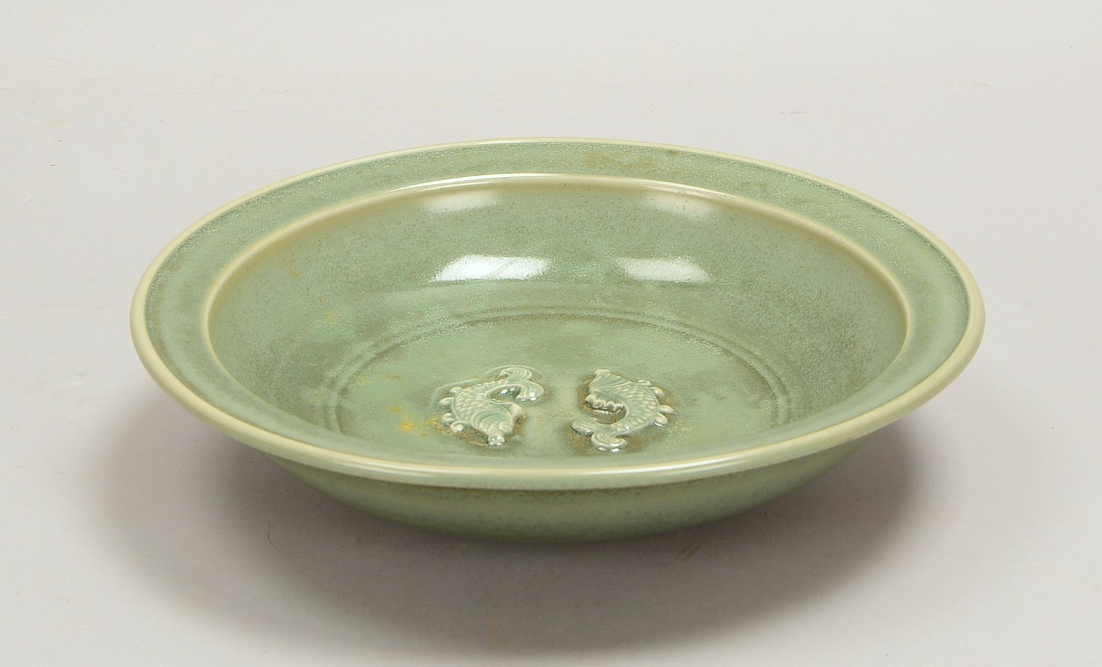 Porzellanschale, seladongrüne Glasur, Spiegel mit Reliefdekor ('Zwei Fische'); Ø 23 cm