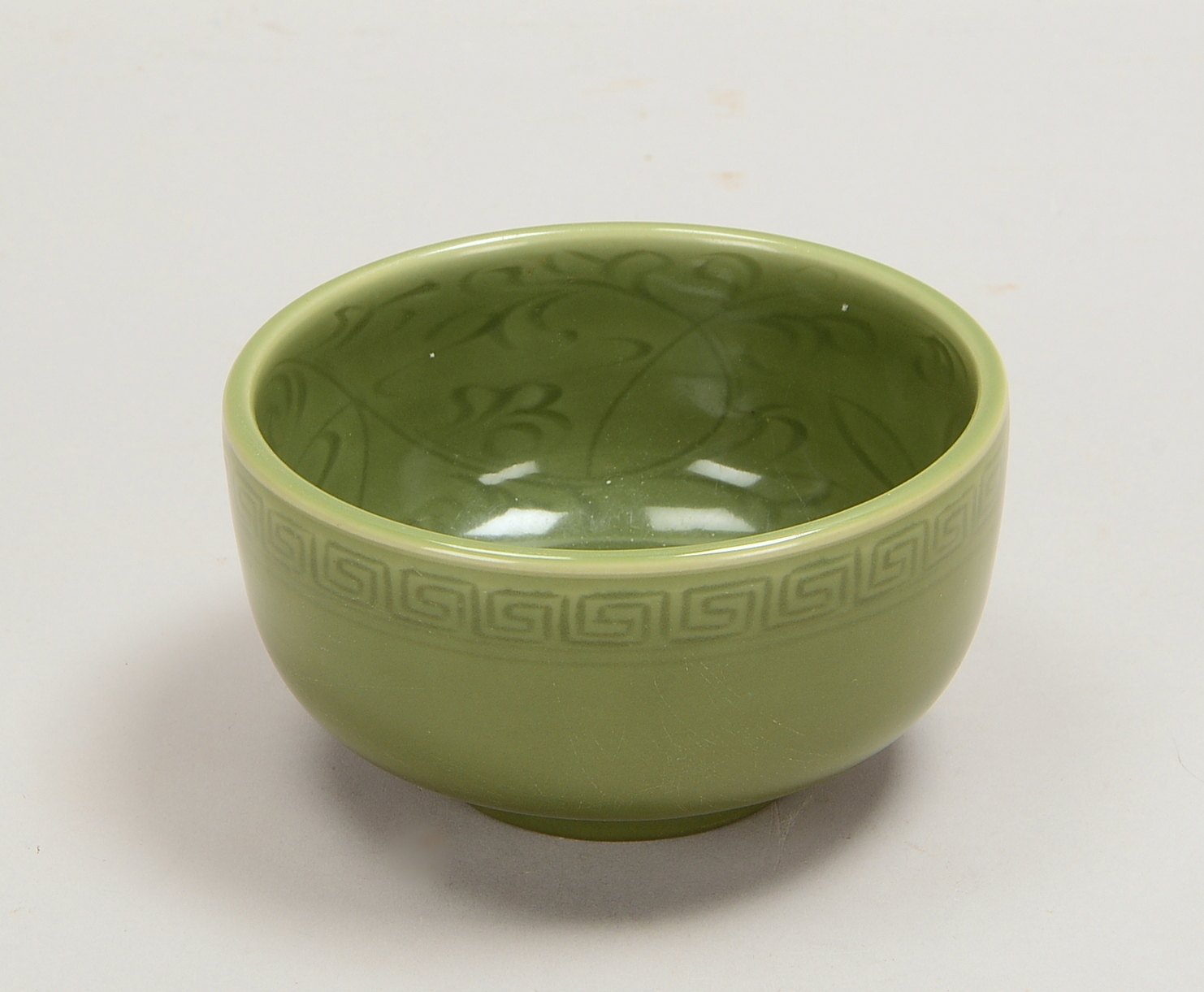 Porzellanschale, dunkelgrüne Glasur, Rand mit Mäanderdekor, innen florales Dekor; Ø 14 cm
