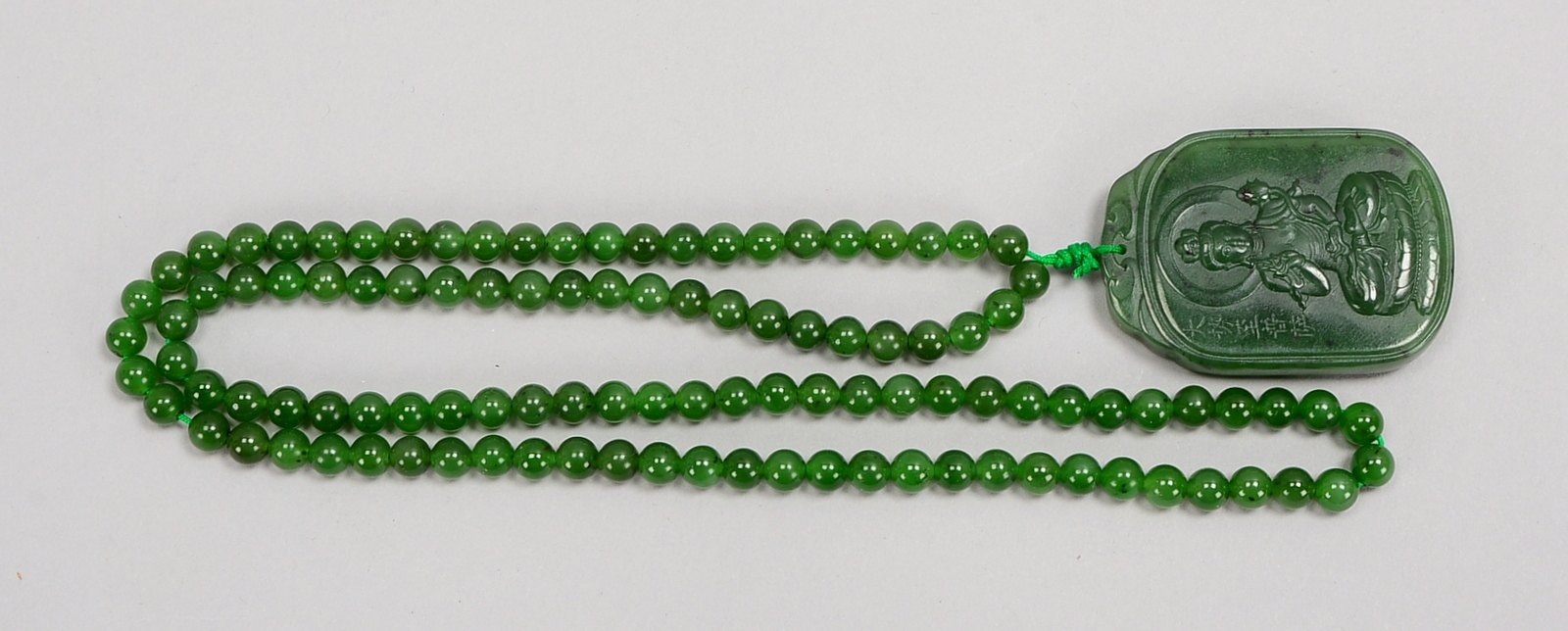 Halskette (China), besetzt mit 108x Jade-Perlen, mit Jade-Amulett; Maße Amulett 5 x 3,5 cm