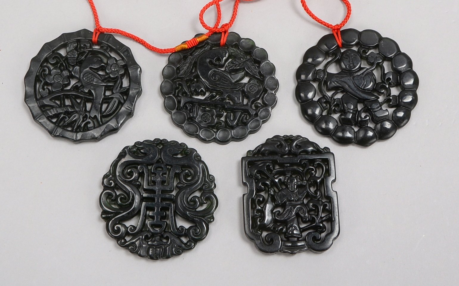 5 Amulette (China), dunkelgrüne Jade - floral und figürlich durchbochen gearbeitet