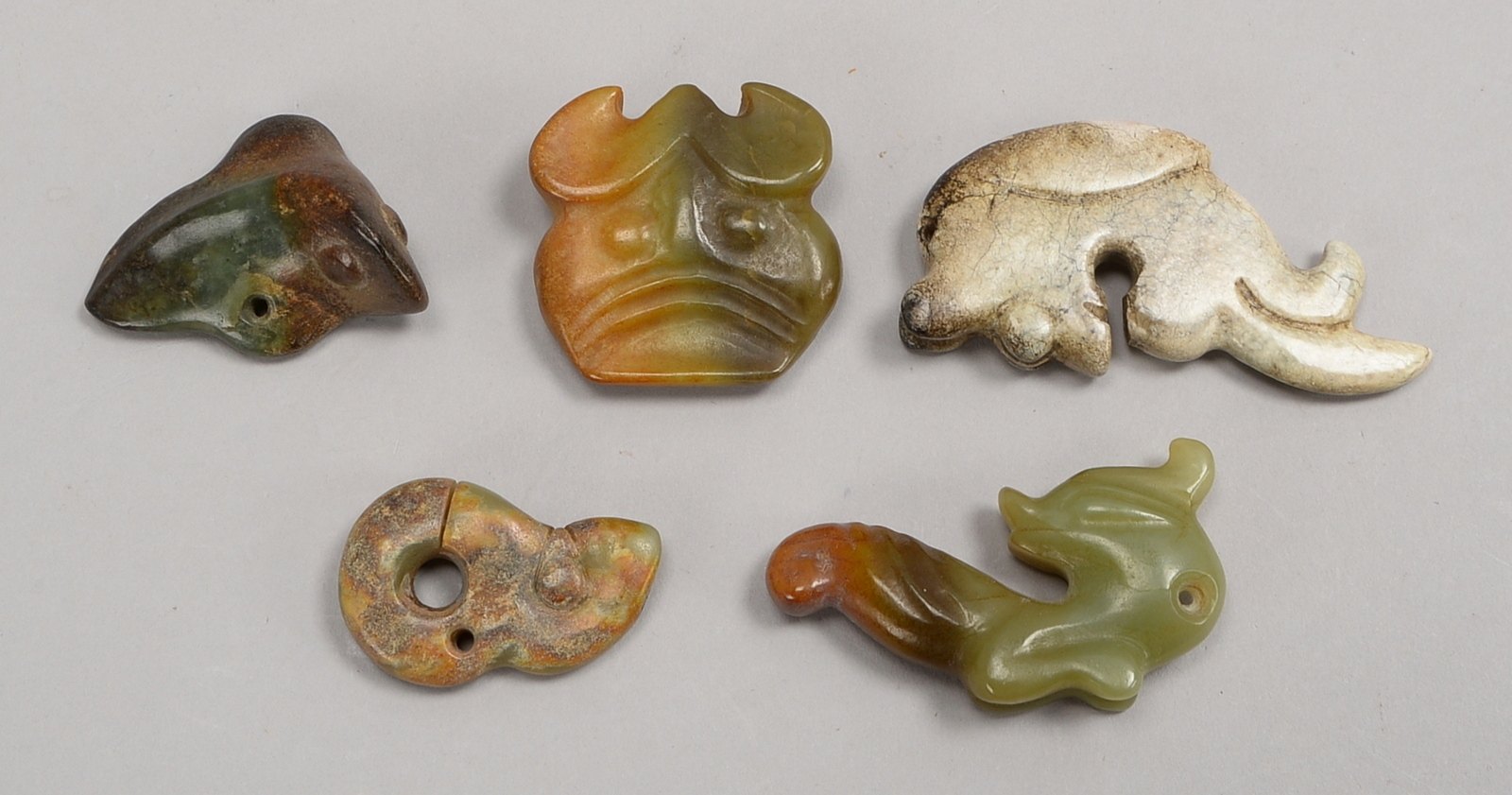 5 Jade-Schnitzereien/Amulette, Tierfiguren/'Fabelwesen', mit Bohrung für Aufh.