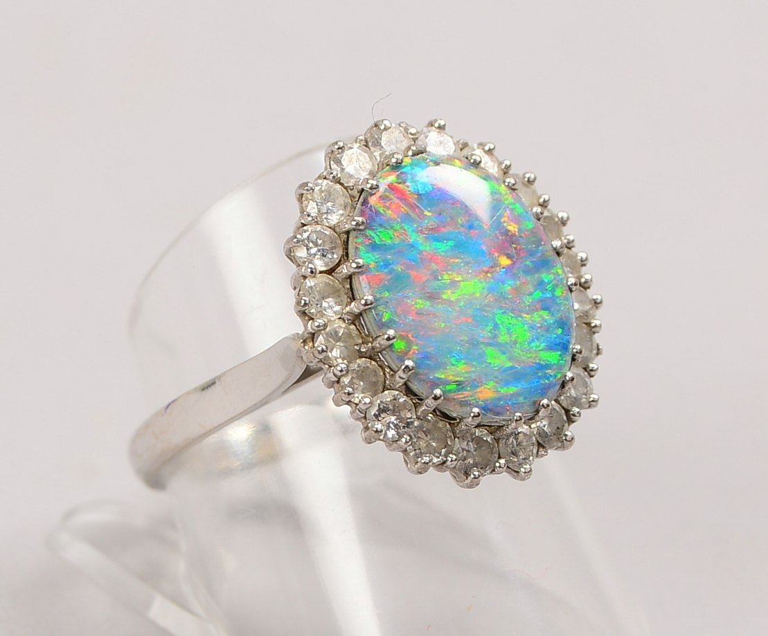 Ring, 585 WG (gest.), Opalcabochon mit Entourage aus Diam.; RG 57, Gewicht 5,50 g