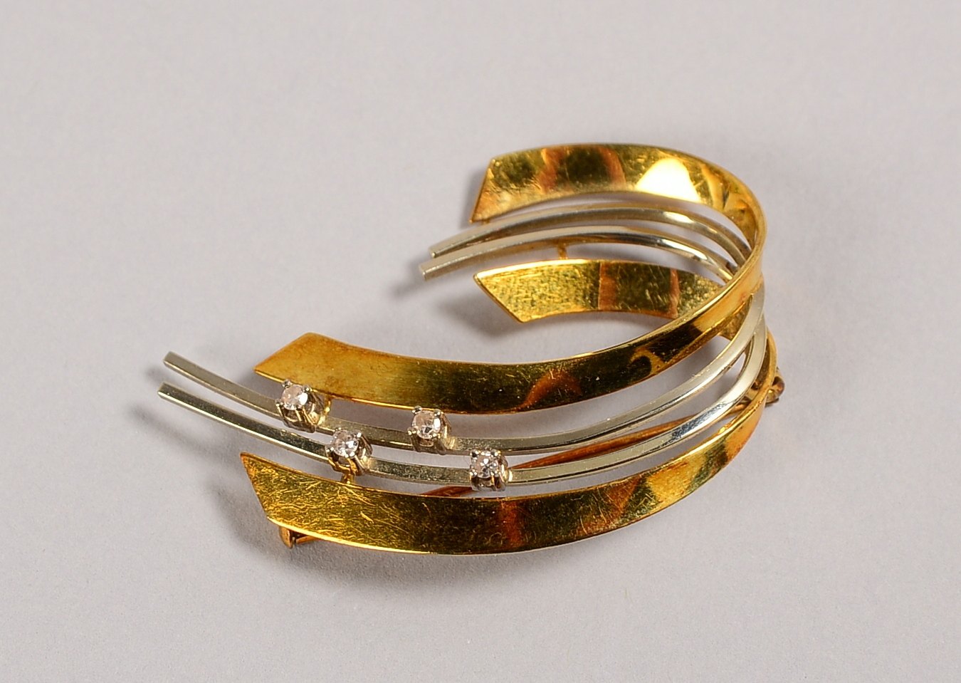 Brosche, 585 GG/WG (gest.), besetzt mit 4x kl. Diamanten; Länge 4 cm, Gewicht 6,10 g