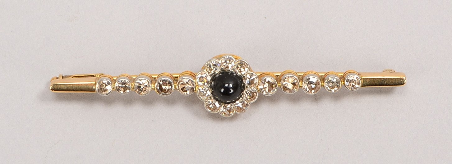 Brosche, 585 GG/WG (gepr.), mit Saphircabochon und 20 Diam./ca. 0,80 ct; Gewicht 5,33 g
