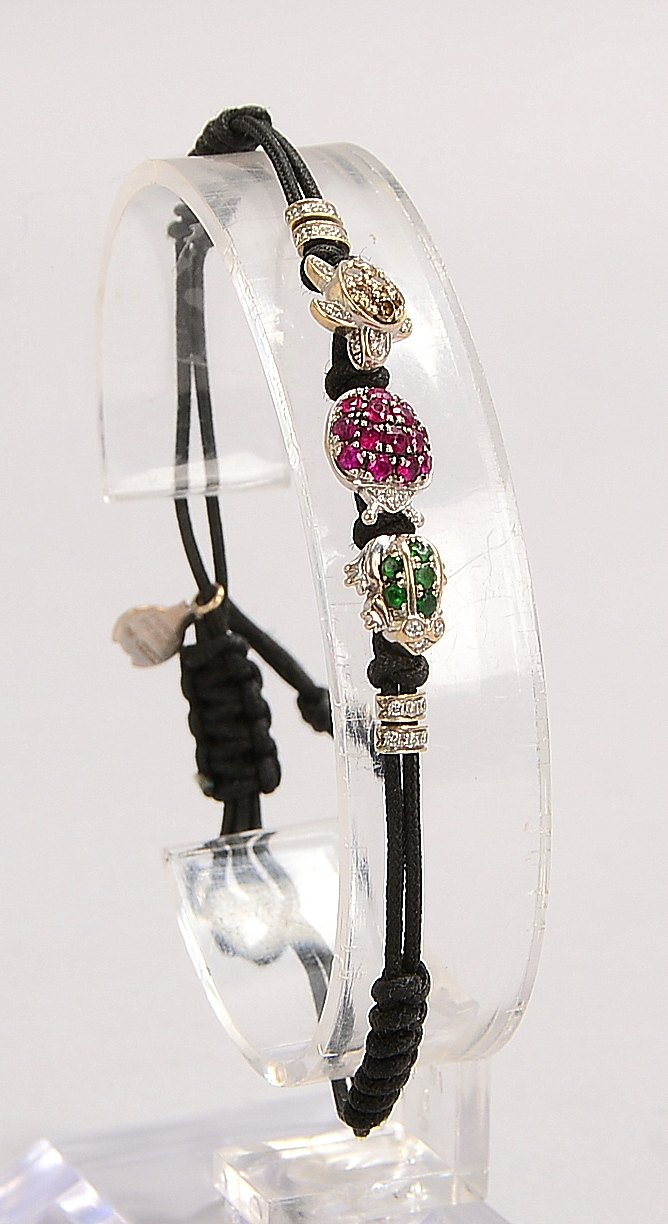 Pippo Perez-Armband, 3x Charms, 750 WG (gest.), jeweils mit Steinbes., an Kordelarmb.