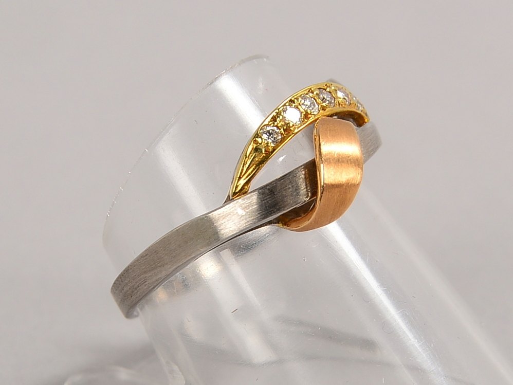 Ring, 585 WG/GG (gest.), besetzt mit 7x kl. Diamanten/ca. 0,07 ct; RG 56, Gew. 3 g