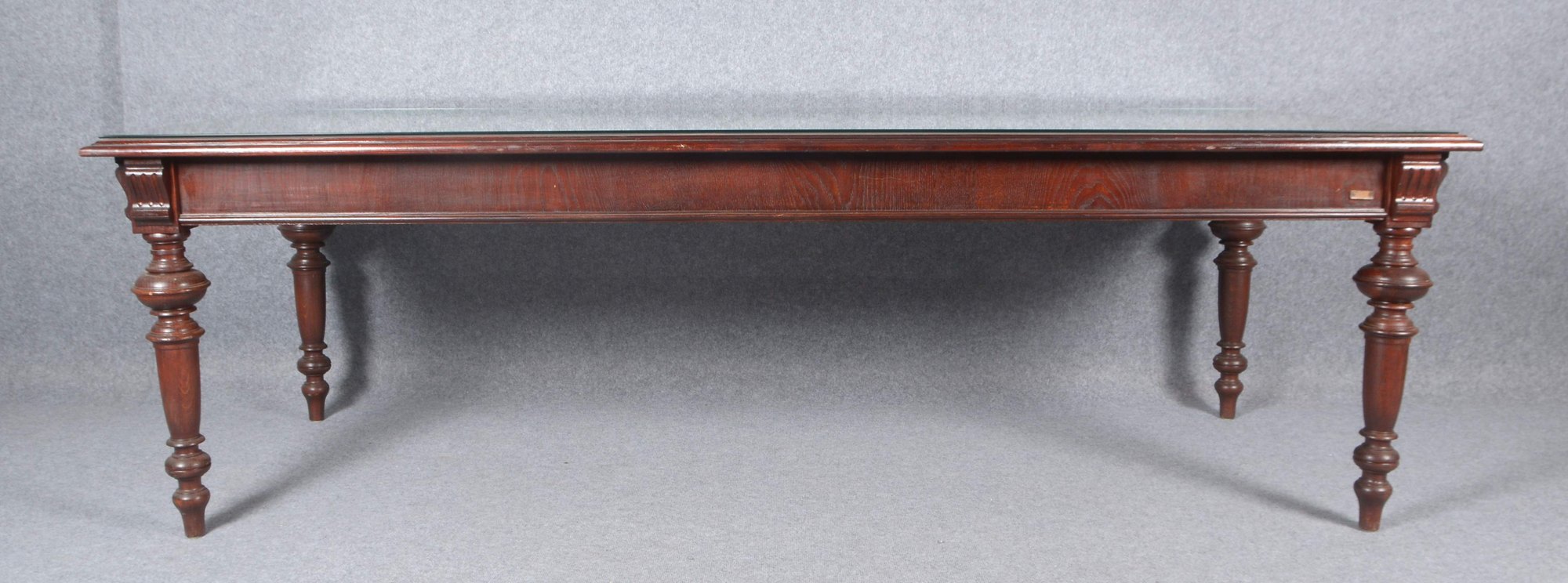 Großer Esstisch, Nadelholz/Mahagoni gebeizt, mit Glasplatte, auf balustrierten Beinen; Höhe 78,5 cm,