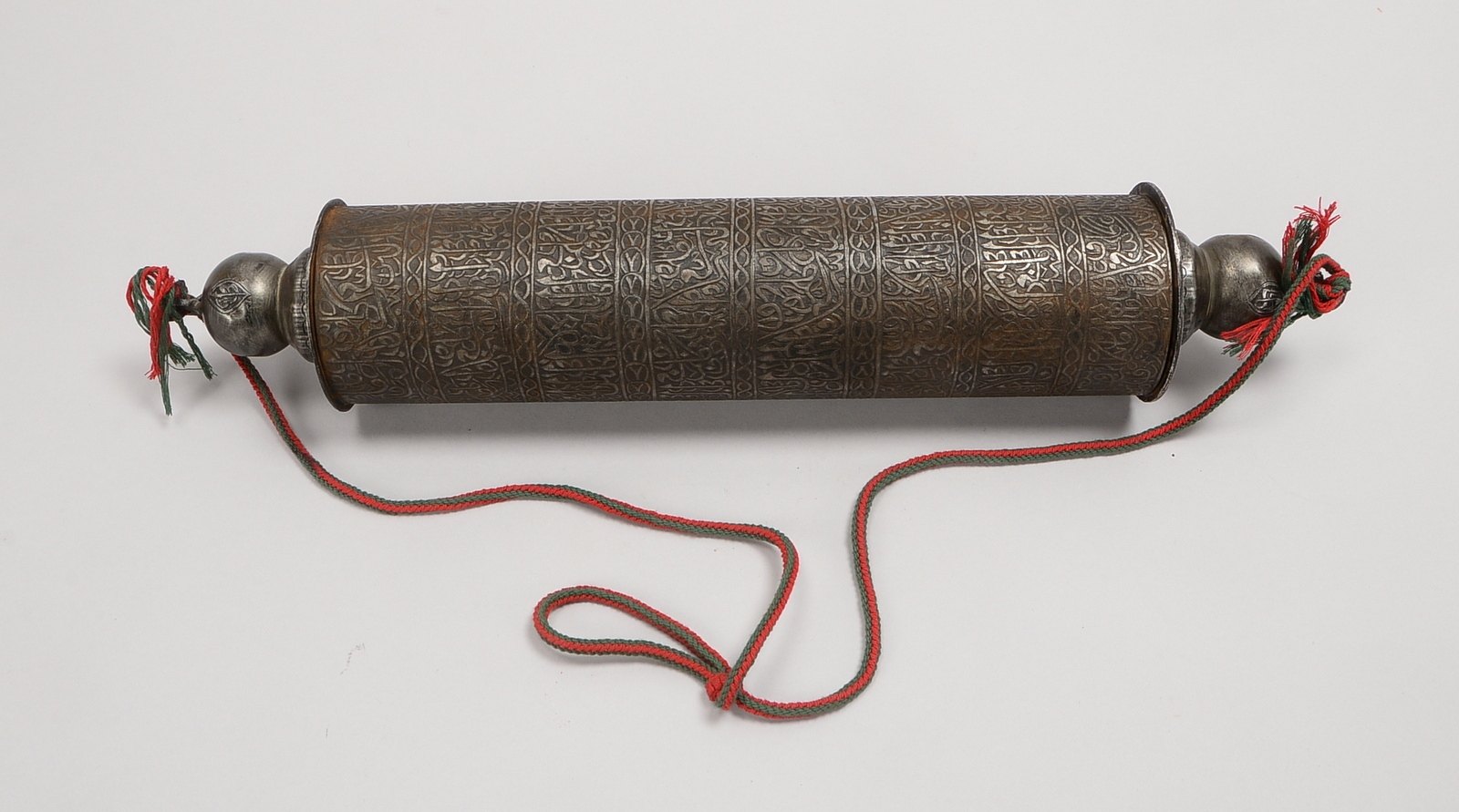 Schriftrollenbehälter (Persien), Eisen, zylindr. Korpus, relief. Kufi-Schrift; Länge 44 cm